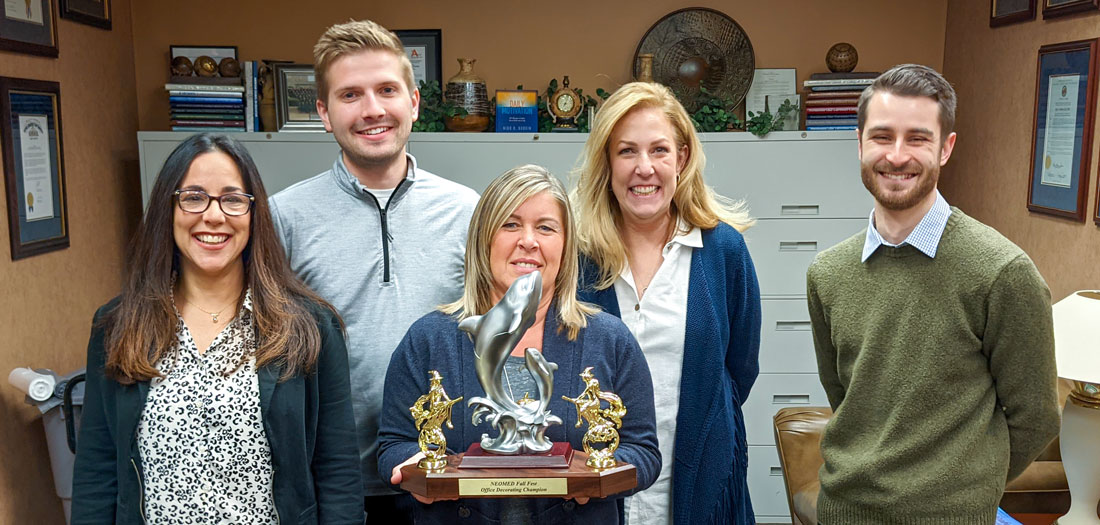 NEOMED Halloween office-decorating trophy, held by five employees.
