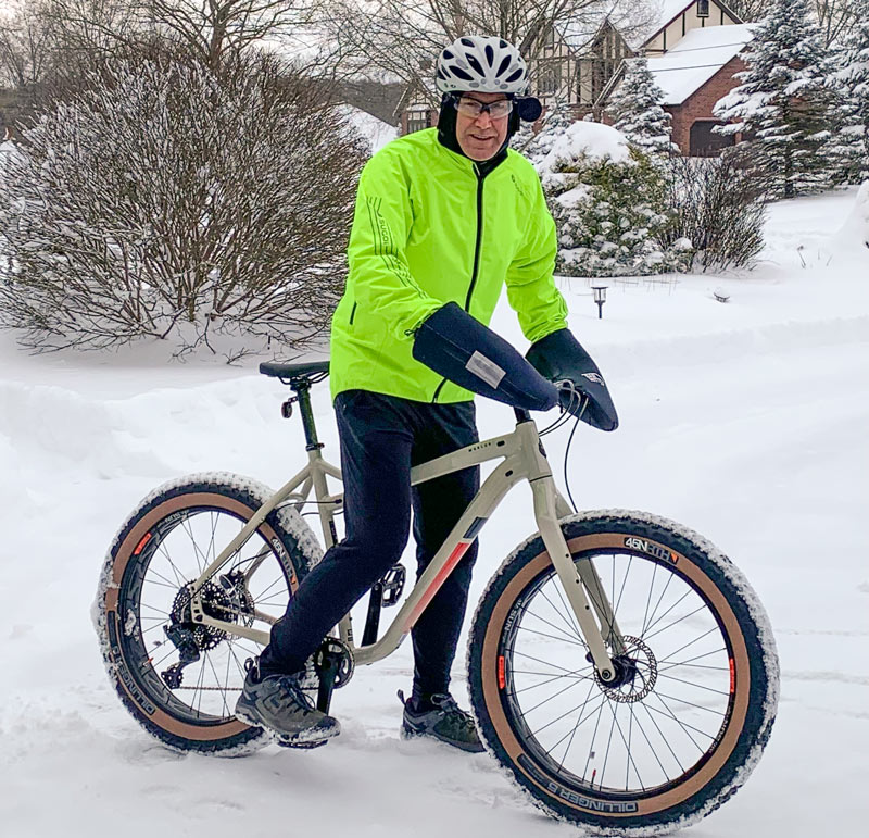 A man on a bicycle in the snow.