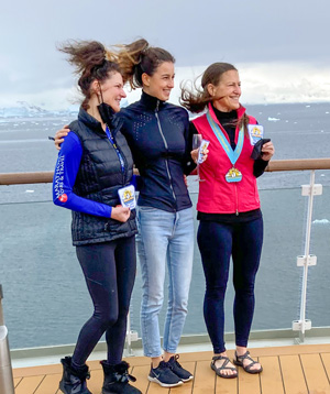 Three runners at a railing on a ship.