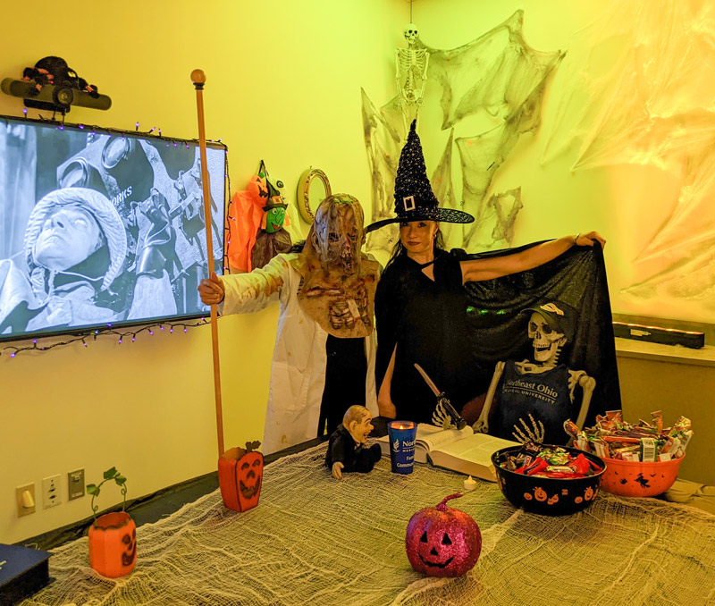 Two witches in a decorated room.