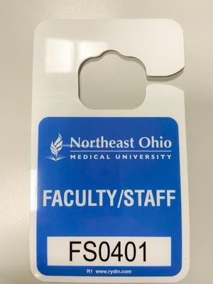 A NEOMED parking permit on a gray background.