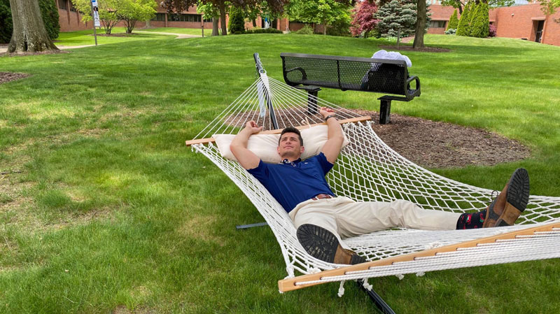 A student lays in a hammock in the courtyard at NEOMED