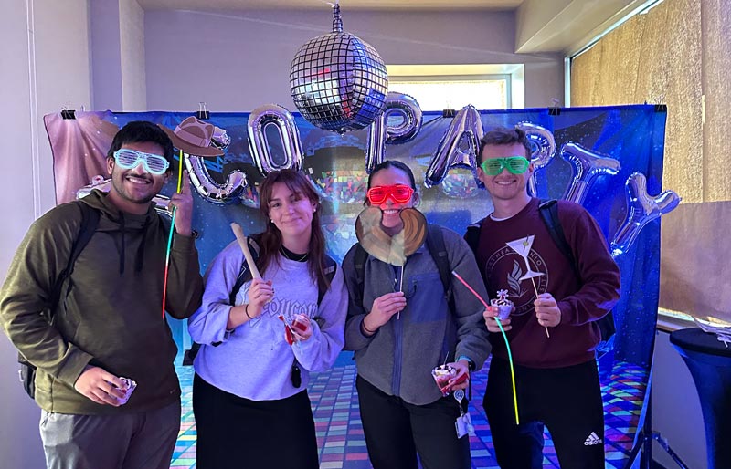 Students pose against a disco backdrop in the president's office.