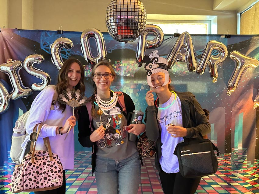 Students pose against a disco backdrop in the president's office.