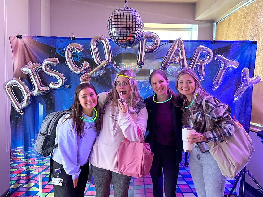 Students pose against a disco backdrop in the president's office.
