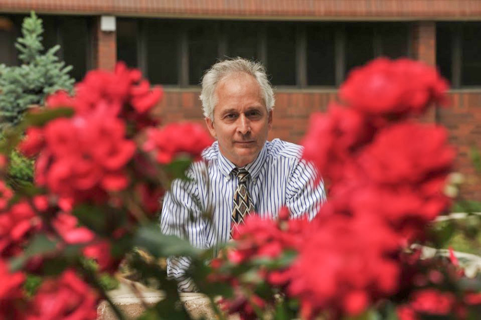 Dr. Paul Hartung appears between two flowers in the foreground.