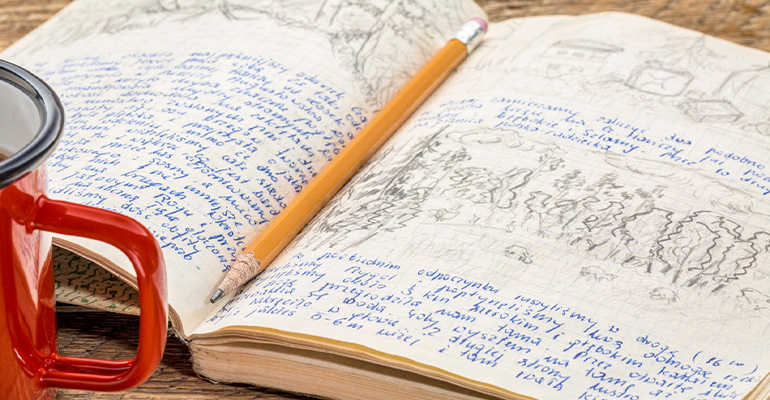 lined journal, opened  with pencil in the center