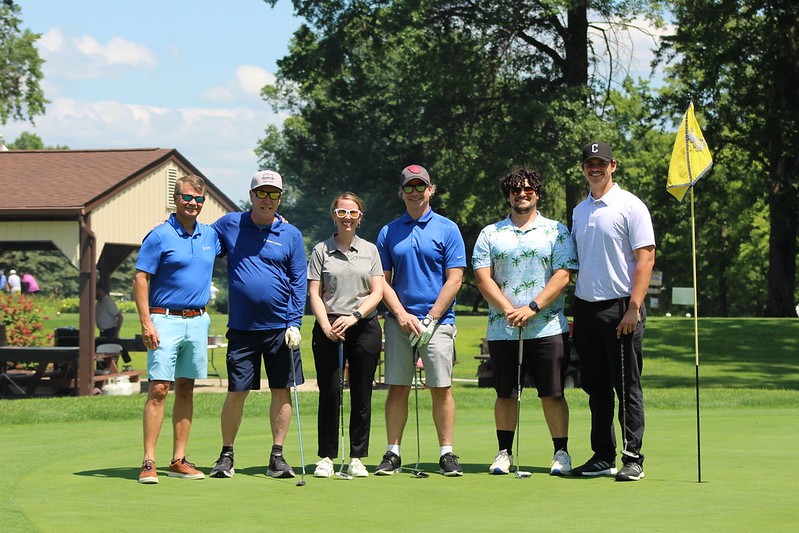 Six golfers pose on the greens