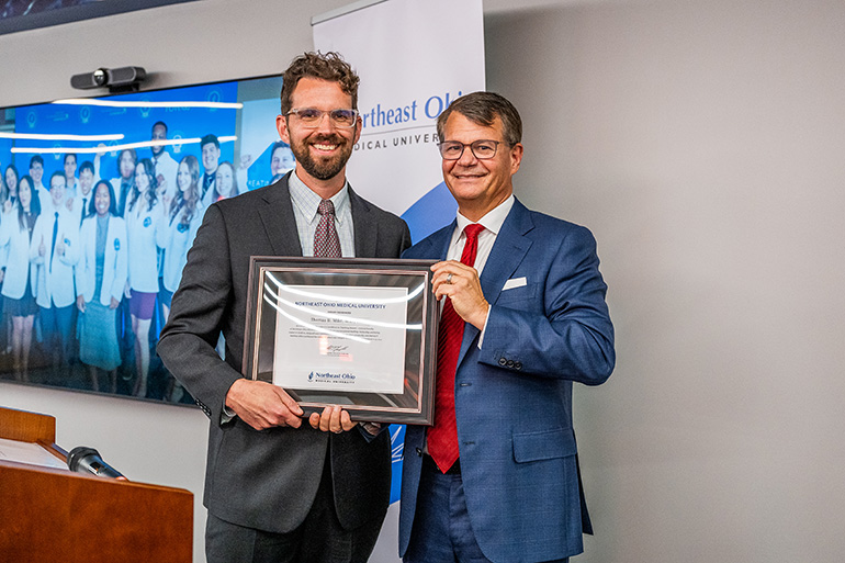 Dr. Jesse Young accepts an award from Dr. John Langell