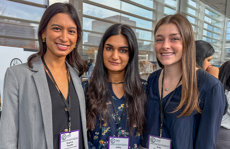 Three young women with conference lanyards