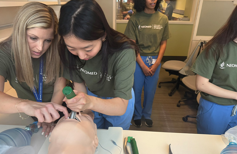Two students practice managing an airway with a training mannequin