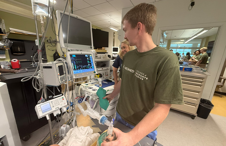 A student practices managing an airway with a training mannequin