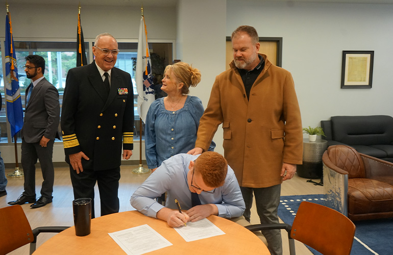 Spencer Dailey signs his military commission
