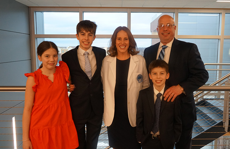 Graduate of the COGS program and family smiliing