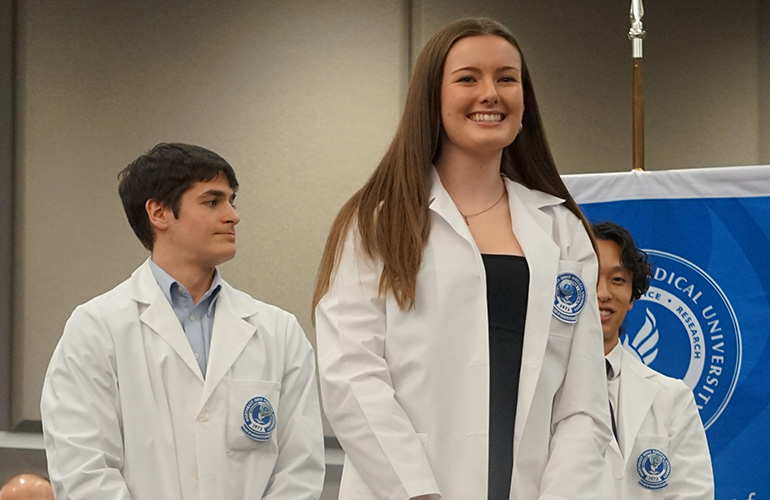 Student graduate smiling after putting on white coat