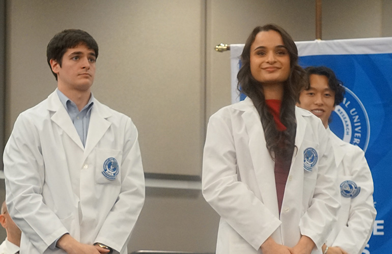 Student graduates smiling after putting on white coat