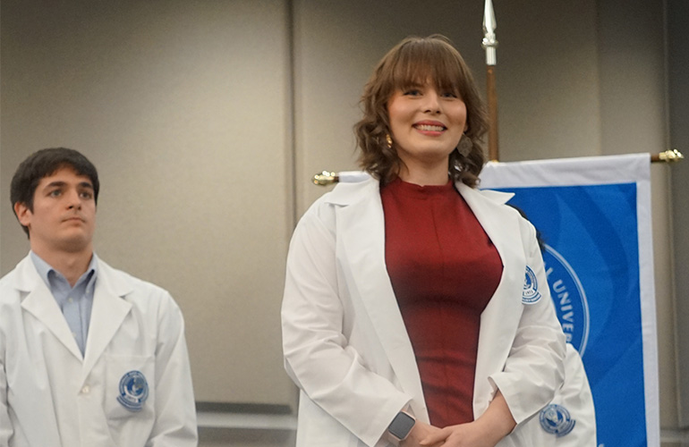 Student graduate smiling after putting on white coat