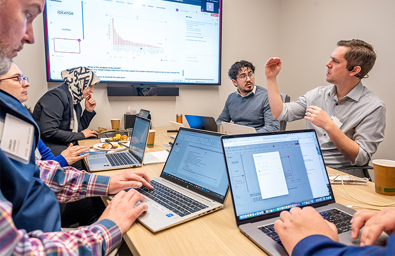 People talking about ideas while on their laptops