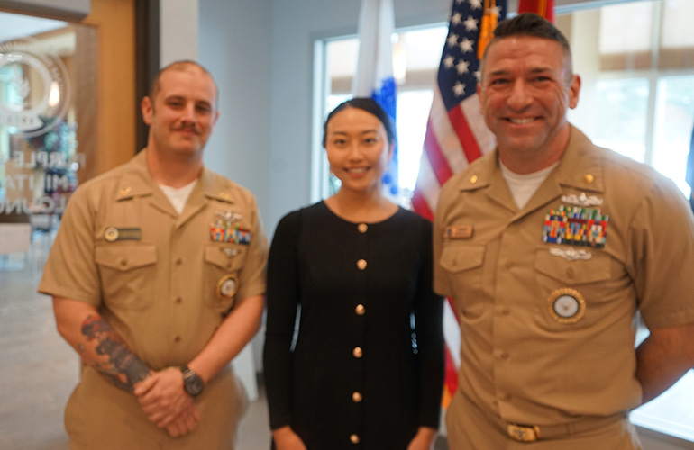 student with Navy recruiters in uniform