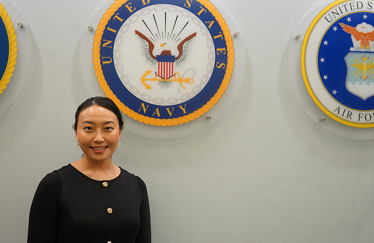Subi Simmons portrait in front of a U.S. Navy seal