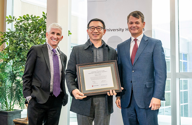Dr. Yong Lu poses with his scholars certificate while Dr. Dan SImon and Dr. John T. Langell look on