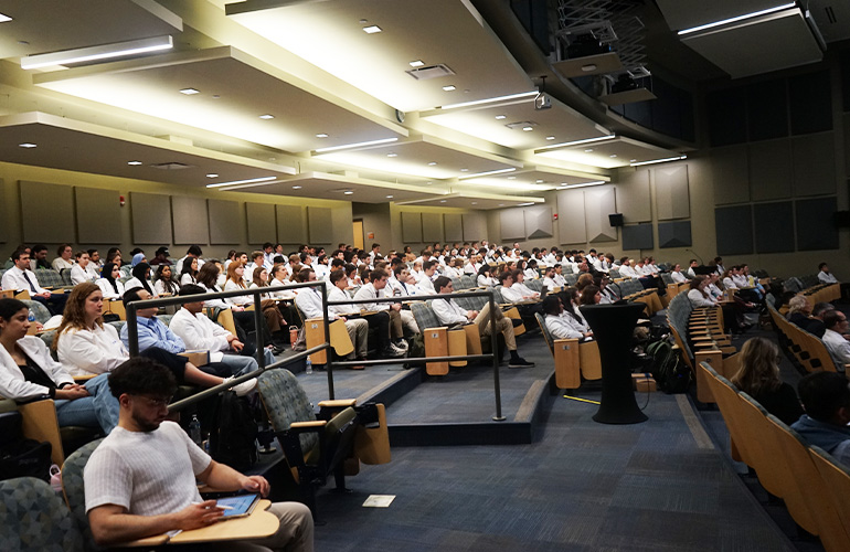 Learners seated in a large lecture hall