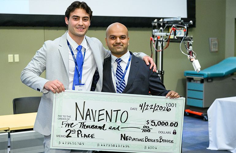 Team Navento poses with an oversized check for $5,000 while standing in a large conference hall