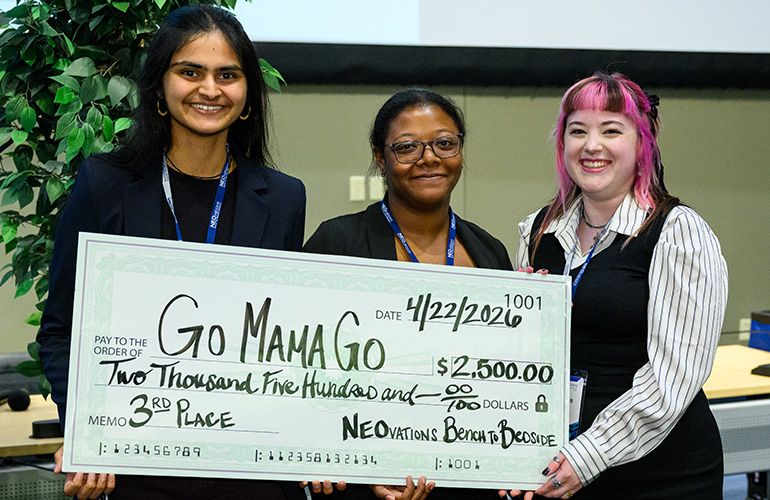 Members of the Go Mama Go team pose with an oversized check for $2,500