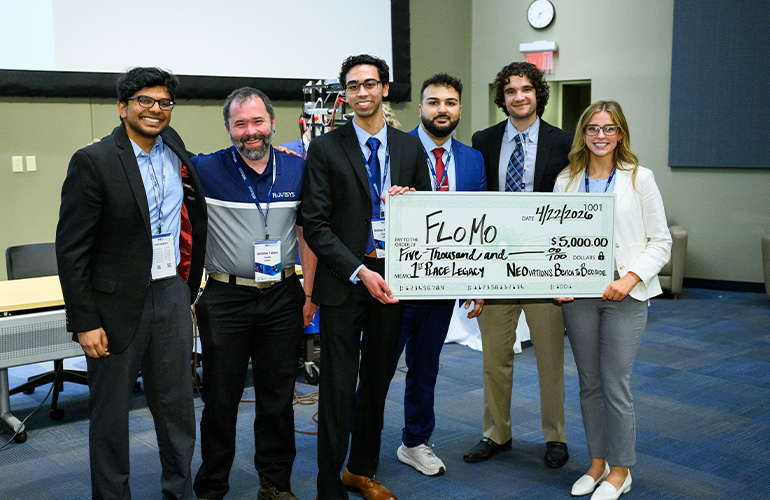 Team FlowMo poses with an oversized check
