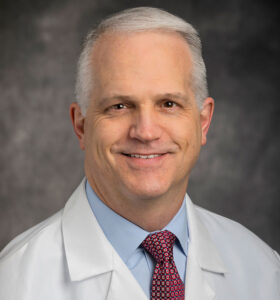 Headshot of Matthew Moorman, M.D., in white coat and a tie