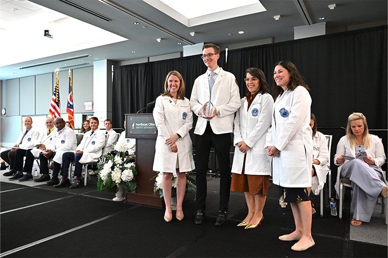 NEOMED College of Pharmacy students and Dean Katherine Tromp smiling at the 2026 Pharmacy White Coat Ceremony
