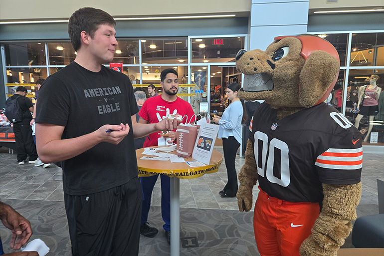 A man talks to the Cleveland Browns mascot