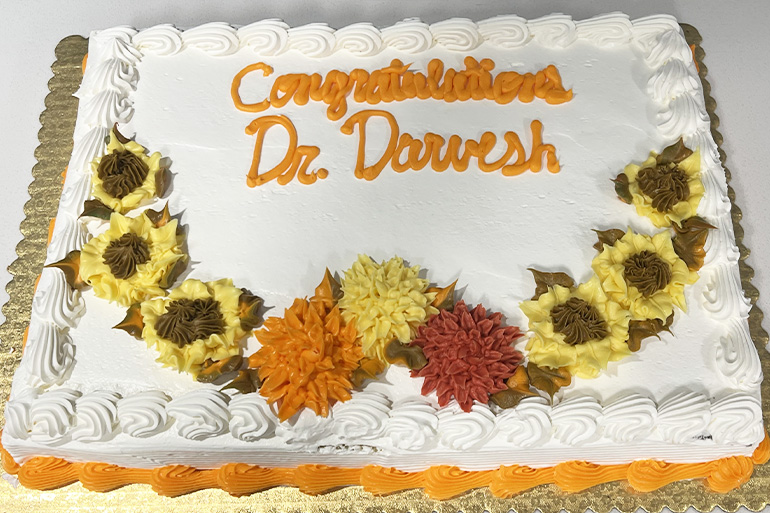 a sheet cake decorated with sunflowers that reads Congratulations Dr. Darvesh
