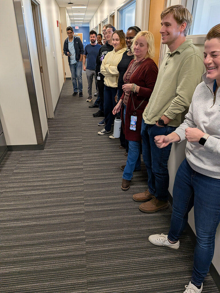 a group of people line up in a hallway