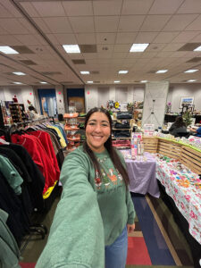 woman in green hoodie takes a selfie while shopping